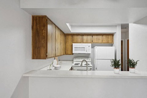 a white kitchen with a stove microwave and refrigerator