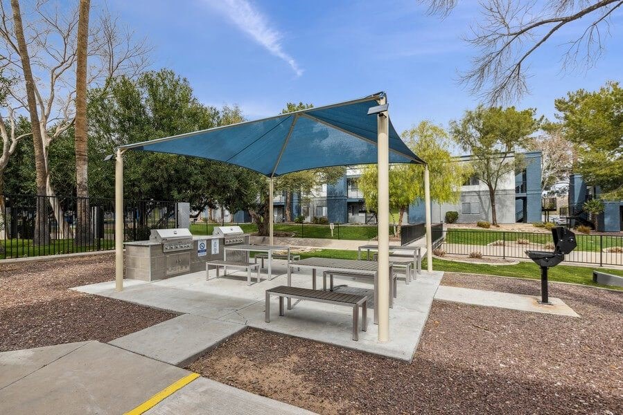a picnic area with benches and a grill at the preserve at great pond apartments in windsor