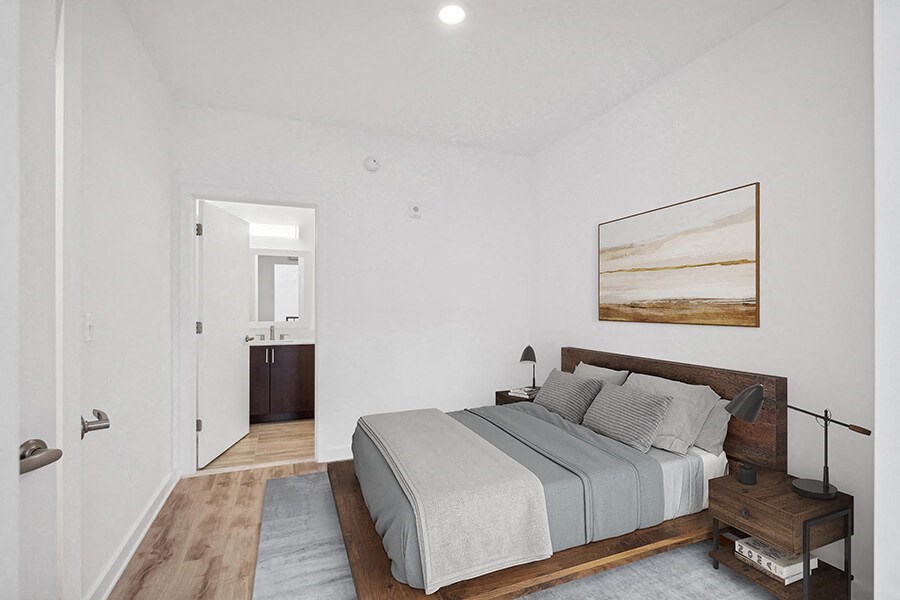Model Bedroom with Wood-Style Flooring and attached Bathroom at Stella Apartments located in New Carrollton, MD.