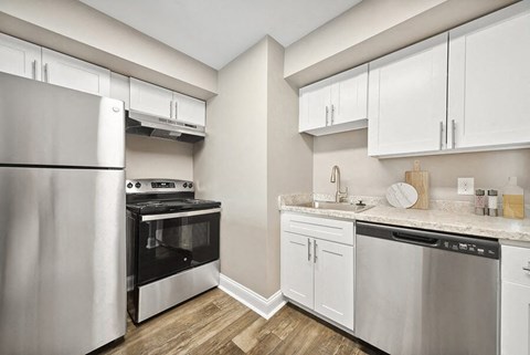 a kitchen with stainless steel appliances and white cabinets