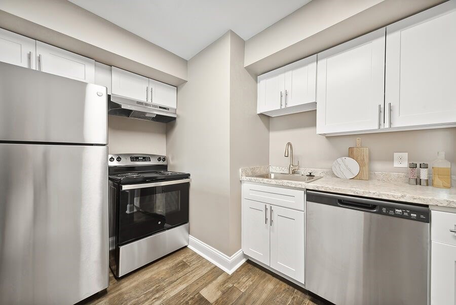 Model Kitchen with White Cabinets and Wood-Style Flooring at Heights at Marlborough Apartments located in Marlborough, MA.