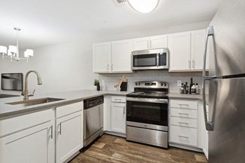 Model kitchen with white cabinetry at Retreat at Stonecrest Apartments - Photo Gallery 6