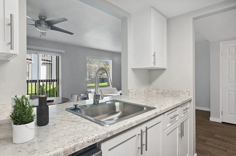 Model Kitchen with White Cabinets and Wood-Style Flooring at Overlook Point Apartments in Salt Lake City, UT.