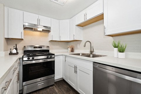 a kitchen with stainless steel appliances and white cabinets