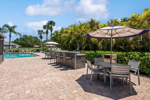 Outdoor BBQ Area with Furniture at Waverley Place Apartments in Naples, FL.