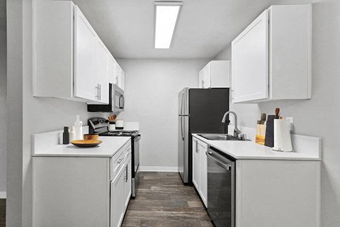 a white kitchen with white cabinets and a black refrigerator
