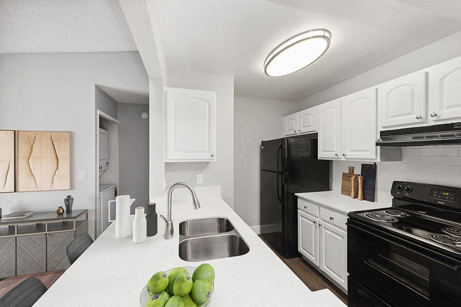 Model Kitchen with White Cabinets and Wood-Style Flooring at Vue at Baymeadows Apartments in Jacksonville, FL.