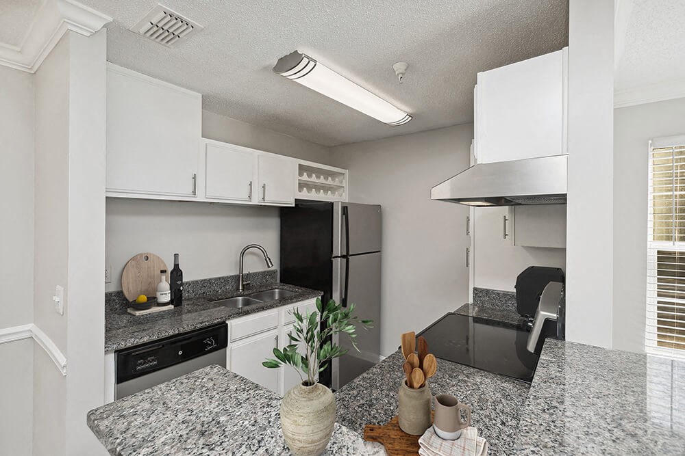 Model Kitchen with White Cabinets and Wood-Style Flooring at Shadow Ridge Apartments in Riverdale, GA.