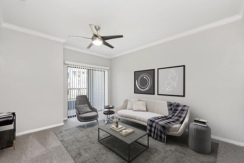 an empty living room with a couch and a ceiling fan