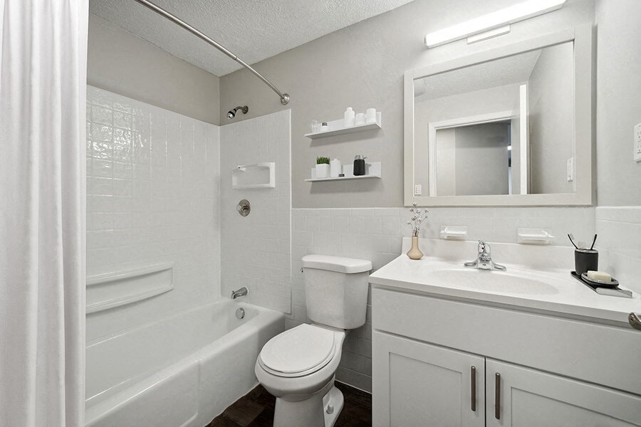 Model Bathroom with White Cabinets, Wood-Style Flooring and Shower/Tub at Middlesex Crossing Apartments in Billerica, MA.