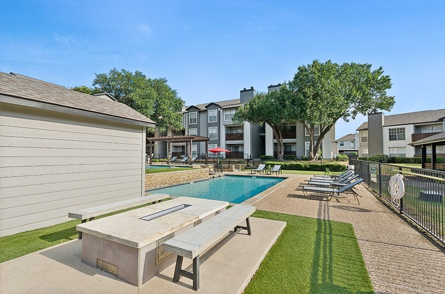 Community Fire Pit Area with View of Swimming Pool at Cobblestone Apartments located in Arlington, TX.