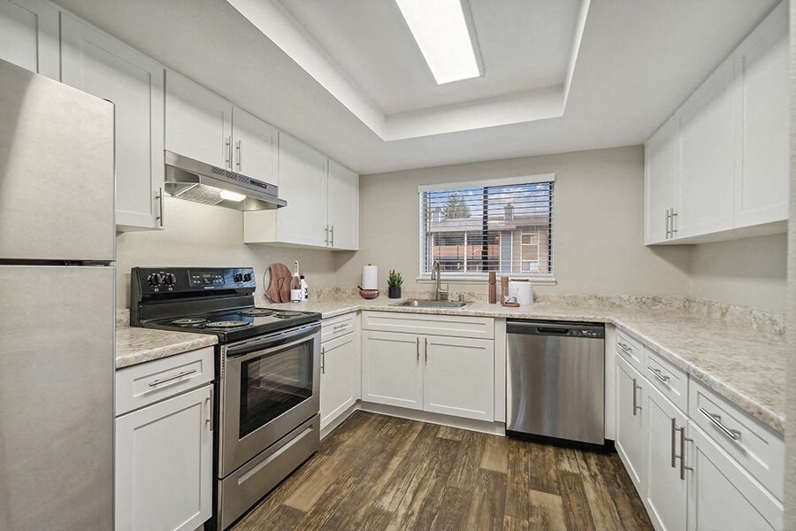 Model Kitchen with White Cabinets and Wood-Style Flooring at Grammercy Apartments located in Renton, WA.