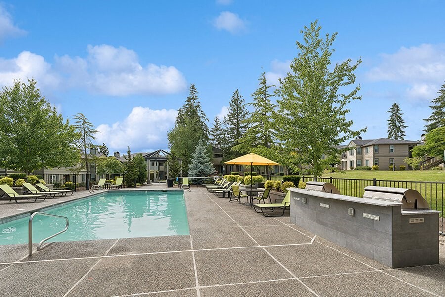 Community Swimming Pool & BBQ Area with Lounge Furniture at The Club Apartments located in Hillsboro, OR.