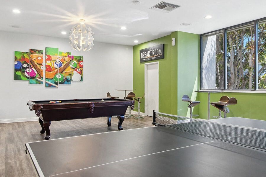 Community Clubhouse with Game Tables and Lounge Furniture at Madison Park Apartments located in Anaheim, CA.