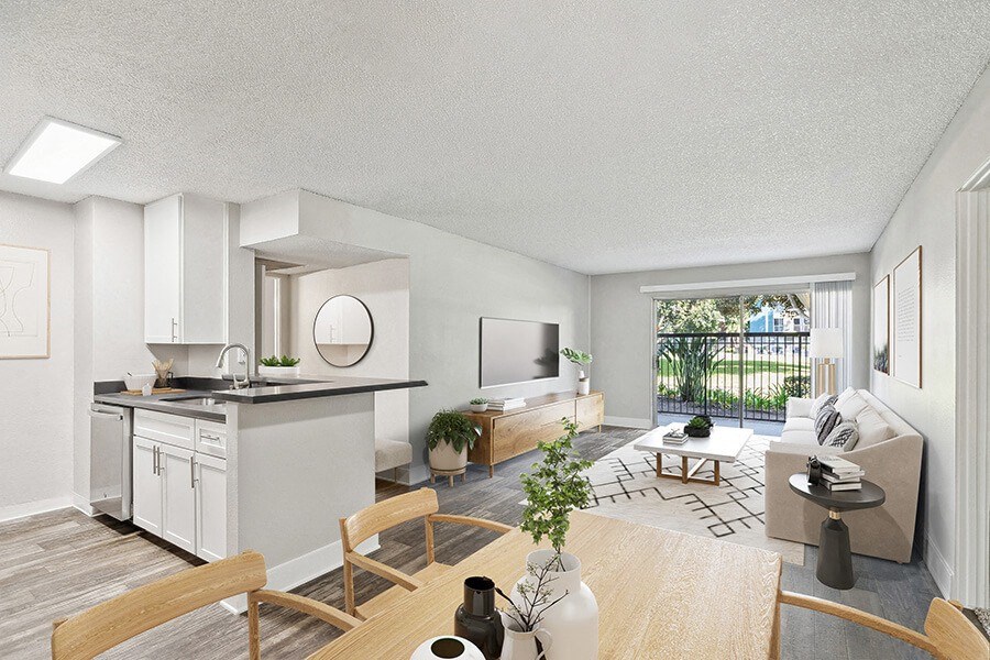 Model Dining Room with Wood-Style Flooring and View of Living Room with Patio Accessibility at Madison Park Apartments located in Anaheim, CA.