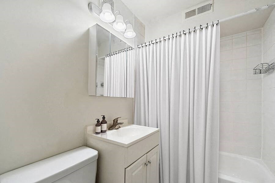 Model Bathroom with White Cabinets and Shower/Tub at Heights Marlborough Apartments in Boston, MA.
