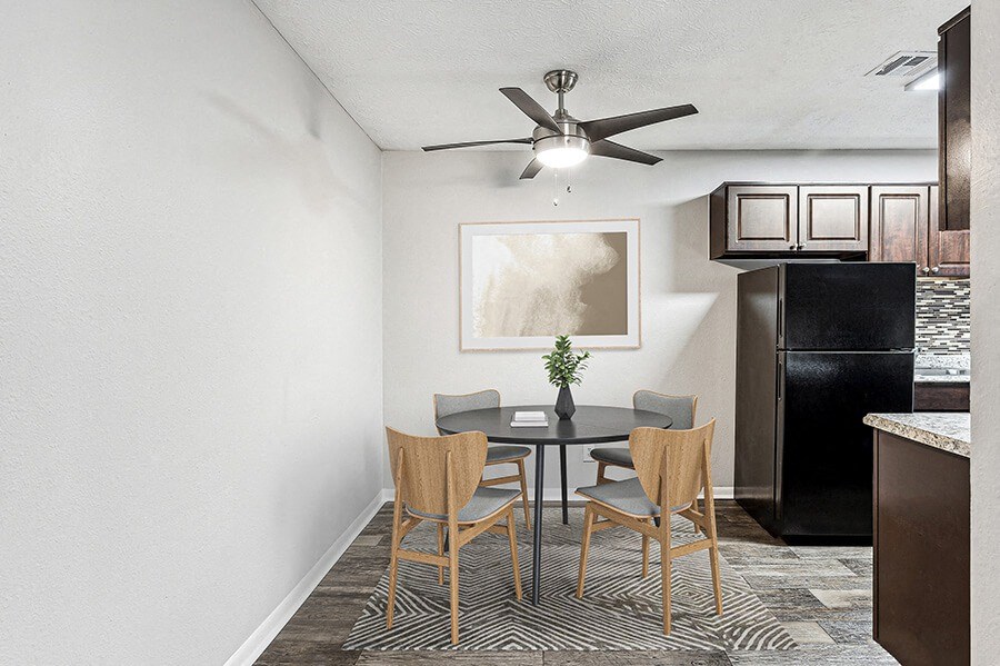 Model Dining Room with Wood-Style Flooring and View of Kitchen at Paramont Apartments in Duluth, GA.