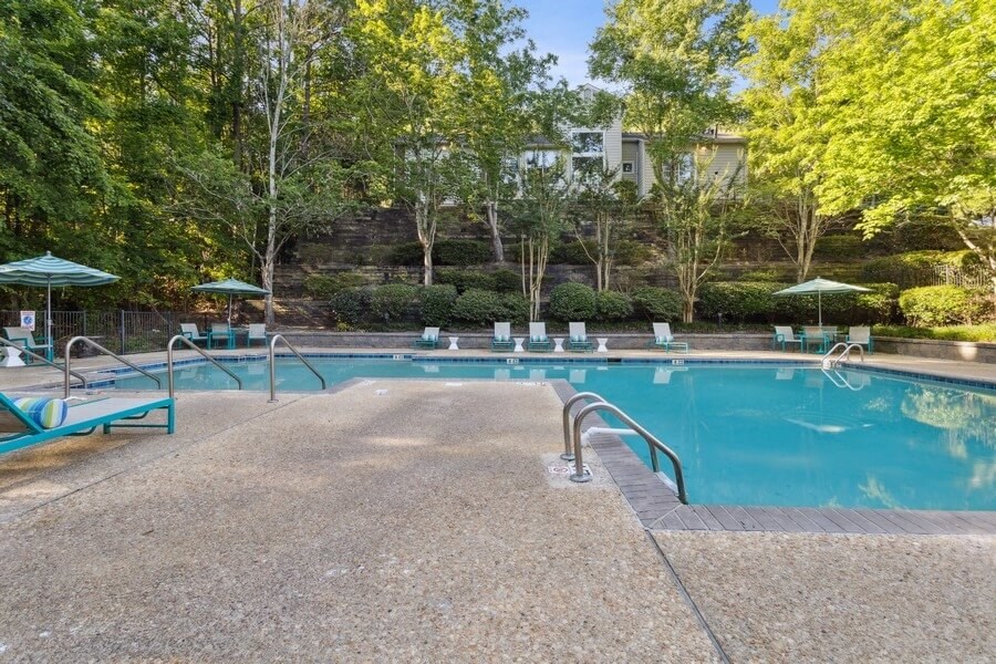 Poolside lounge chairs and cabanas next to large swimming pool