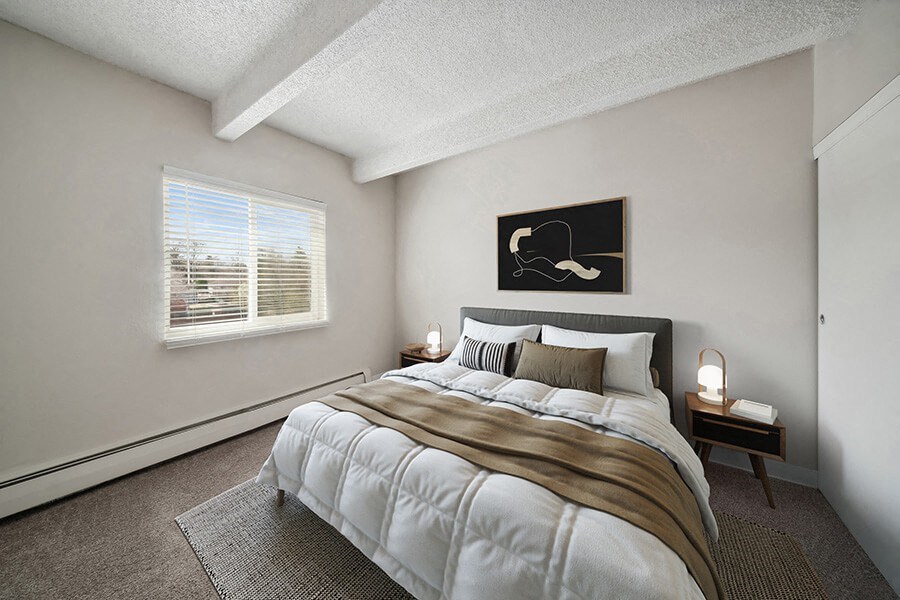 Model Bedroom with Carpet and Window View at Esprit Cherry Creek Apartments in Glendale, CO.