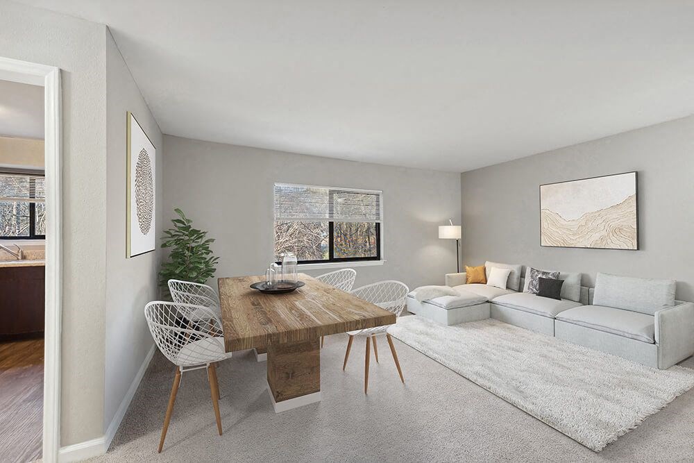 Model Living Room with Carpet and View of Dining Room at Spring Forest Apartments in Raleigh, NC.