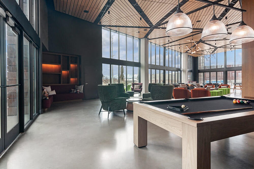 Sleek and modern resident lounge area with high-end billiards table and finishes