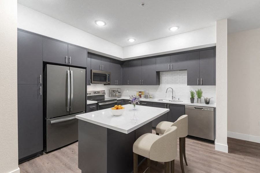 Model kitchen with dark cabinetry and bar