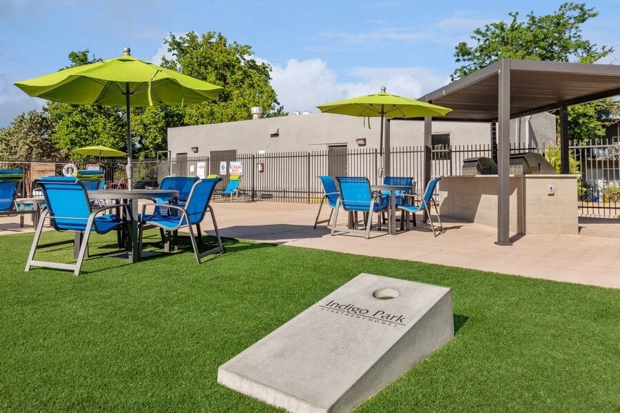 Outdoor Corn Hole and BBQ Area with Covered Patio Furniture at Indigo Park Apartments in Albuquerque, NM.
