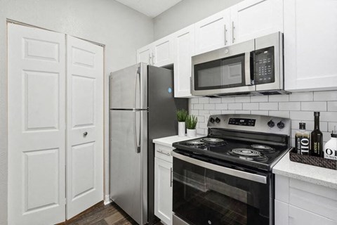 a kitchen with stainless steel appliances and white cabinets