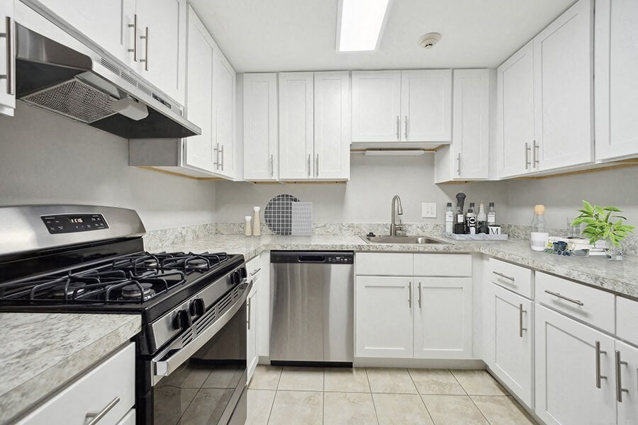 Model Kitchen with White Cabinets and Tile Flooring at Middlesex Crossing Apartments in Billerica, MA.