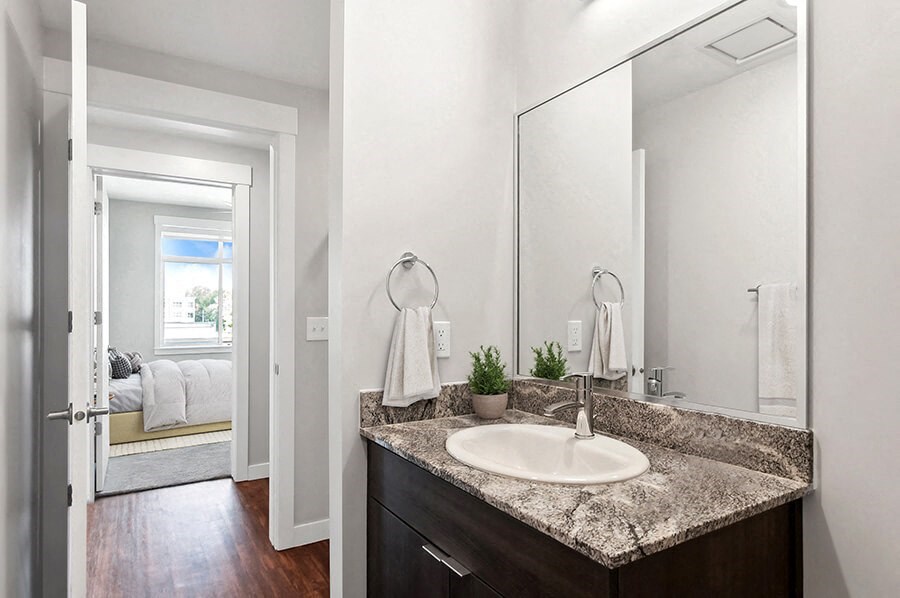 Model Bathroom with Wood-Style Flooring and Dark Oak Cabinets at Seven Skies Apartments located in Sandy, UT.