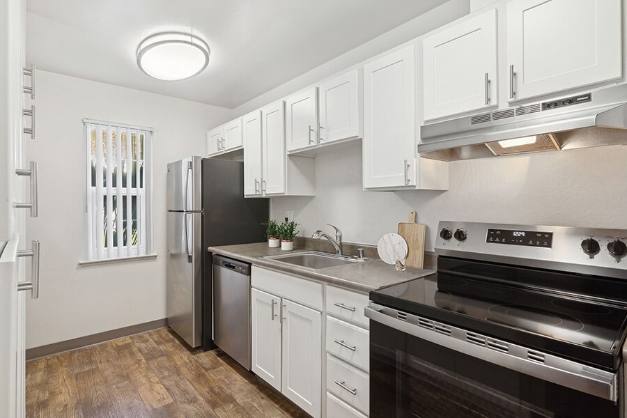 Model Kitchen with White Cabinets and Wood-Style Flooring at Los Gatos Landing Apartments located in San Jose, CA.