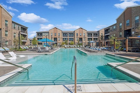 Community Swimming Pool with Pool Furniture at Alta 3Eighty Apartments located in Aubrey, TX.