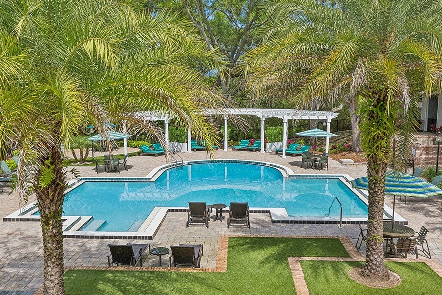 Aerial View of Community Swimming Pool with Pool Furniture at Grand Pavilion Apartments in Tampa, FL.