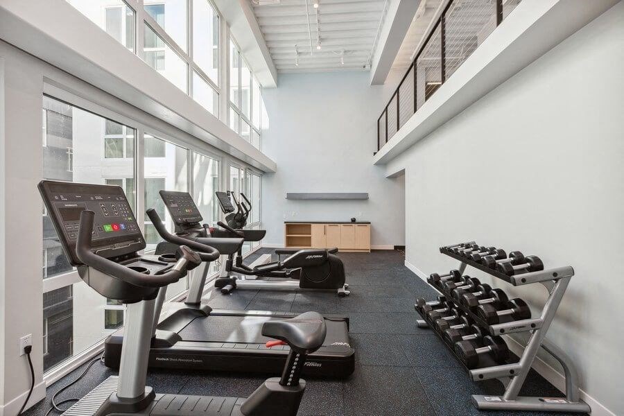 Fitness center with cardio equipment and large sun windows at TL Residences