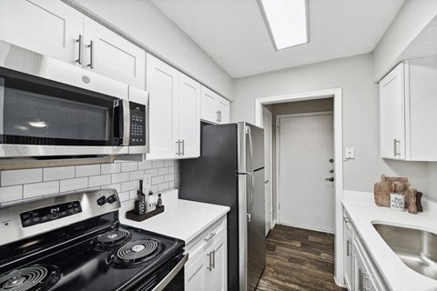a kitchen with a stove and a microwave and a refrigerator