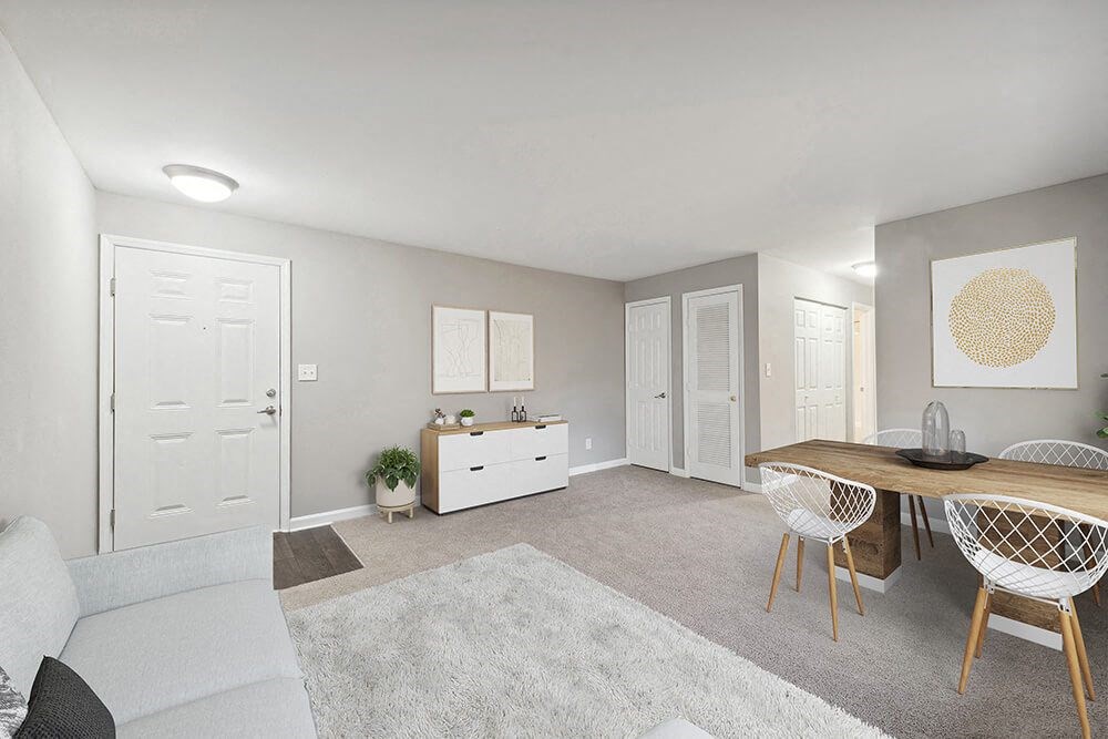 Model Living Room with Carpet and View of Dining Room at Spring Forest Apartments in Raleigh, NC.