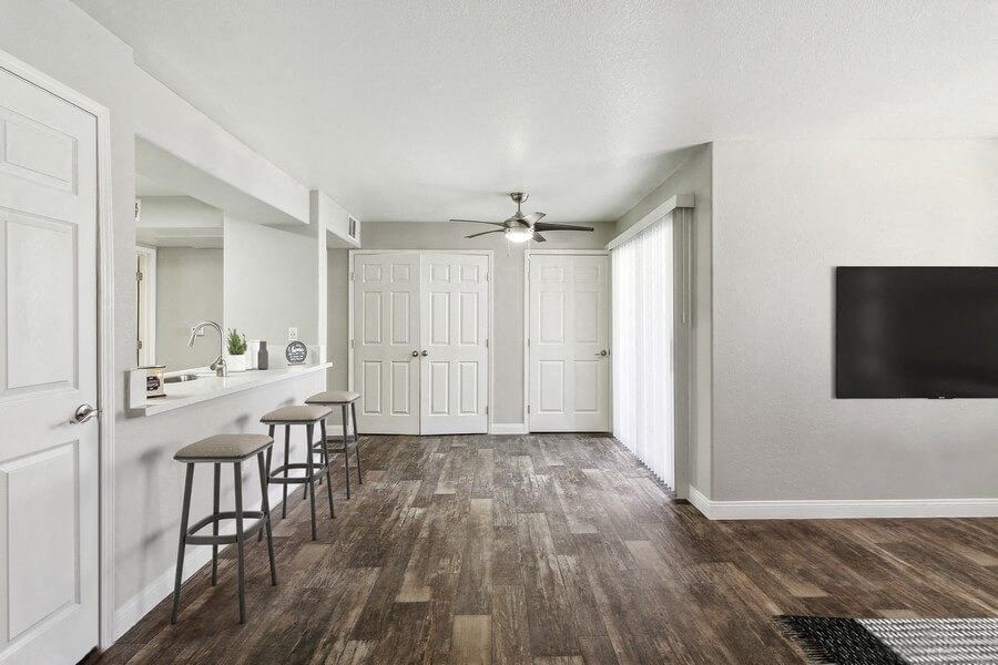 Model living area with a ceiling fan and three stools