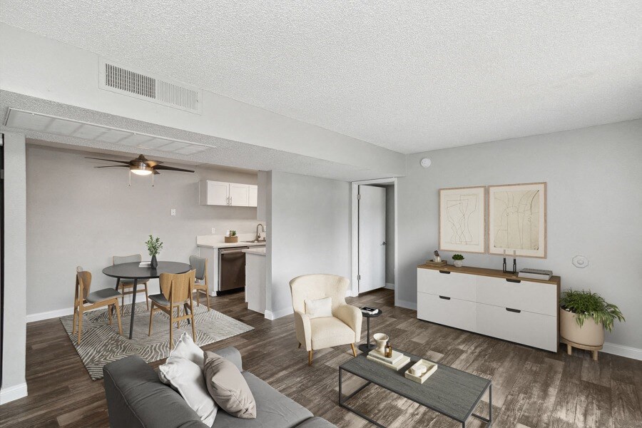 the living room and dining room of an apartment with a table and chairs