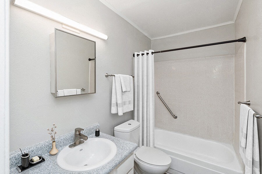 Model Bathroom with White Cabinets, Wood-Style Flooring and Shower/Tub at Indigo Park Apartments located in Albuquerque, NM.