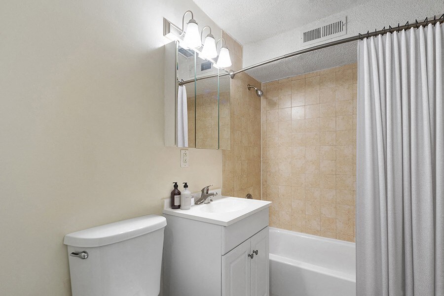 Model Bathroom with White Cabinets and Wood-Style Flooring  at Meadows at Marlborough Apartments in Boston, MA.