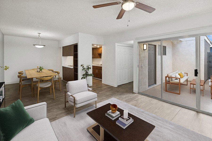 Model Living Room with Wood-Style Flooring, View of Kitchen and Patio Accessibility at Lakeside Casitas Apartments located in Tucson, AZ.