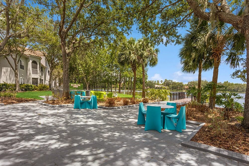 Patio with blue tables and chairs with the lake in the background
