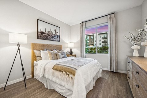 Model Bedroom with Wood-Style Flooring and Window View at Glen 91 Apartments located in Glendale, AZ.
