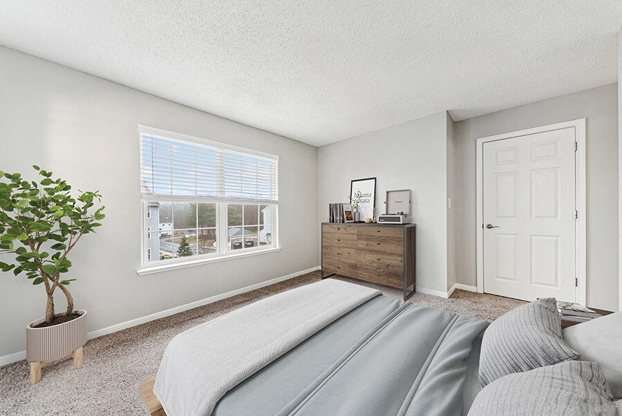 Model Bedroom with Carpet and Window View at Commons at Haynes Farm Apartments in Shrewsbury, MA.