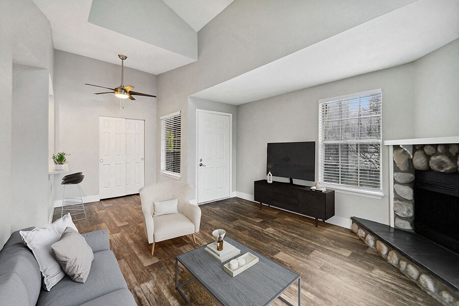 Model Living Room with Wood-Style Flooring, a Fireplace and Patio Accessibility at Central Flats Apartments in Kent, WA.