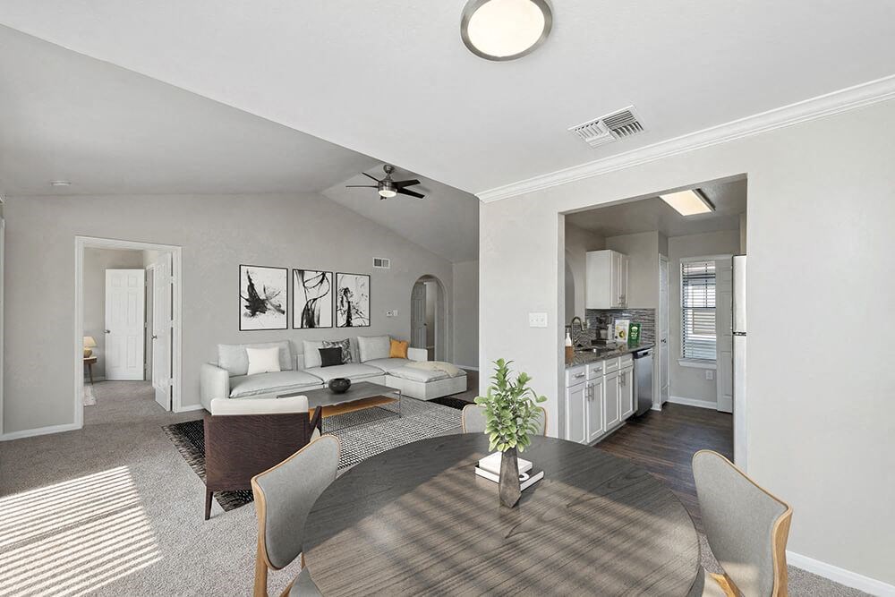 Model Dining Room with Carpet and View of Kitchen and Living Room at Hidden Creek Apartments in Lewisville, TX.