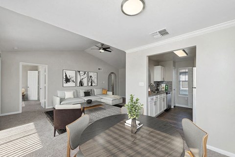 Model Dining Room with Carpet and View of Kitchen and Living Room at Hidden Creek Apartments in Lewisville, TX.