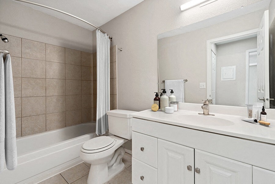 Model Bathroom with White Cabinets and Tile Flooring at Liberty Creek Apartments in Aurora, CO.