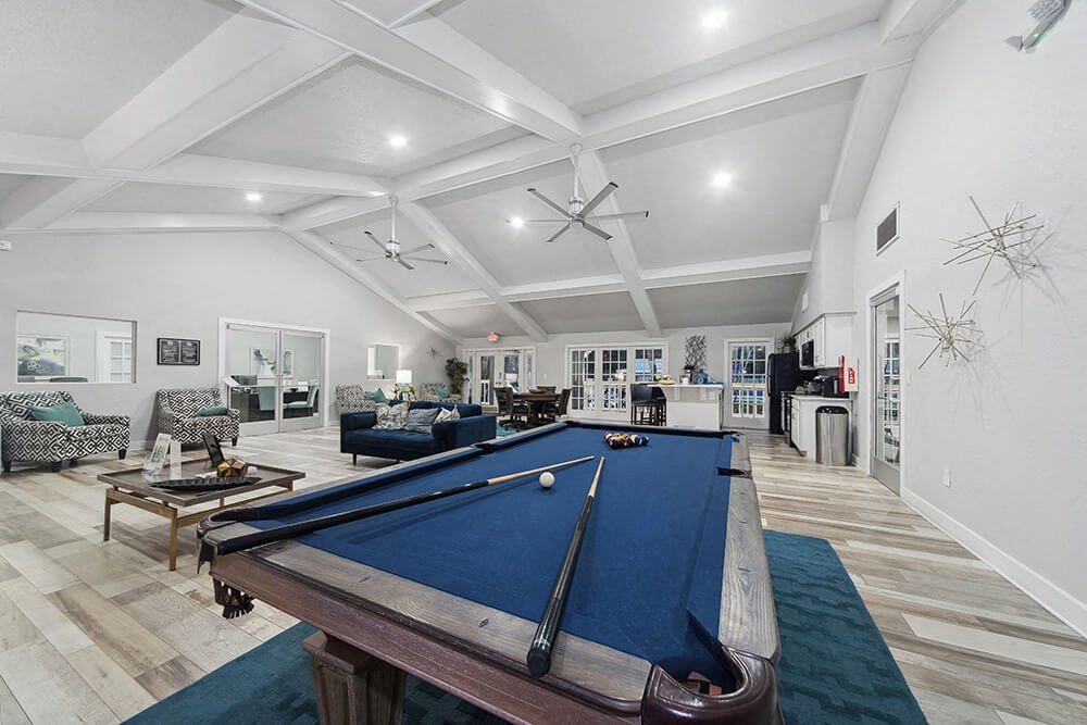 Community Clubhouse with Lounge Furniture and Pool Table Area at Walden Lake Apartments in Plant City, FL.