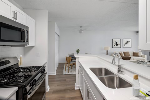 A modern kitchen with a black stove top oven and white cabinets.